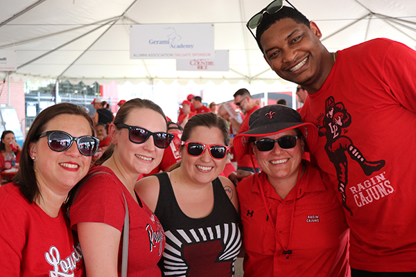 UL Lafayette alumni stop for a photo during tailgating with the Alumni Association